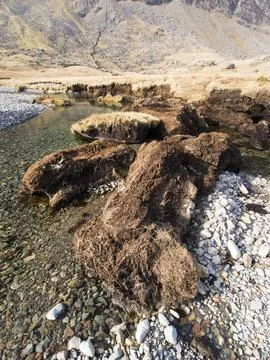 Huge chunks of peat eroded from the side of the Upper Esk by extreme flooding Stock Photos