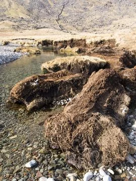 Huge chunks of peat eroded from the side of the Upper Esk by extreme flooding Stock Photos