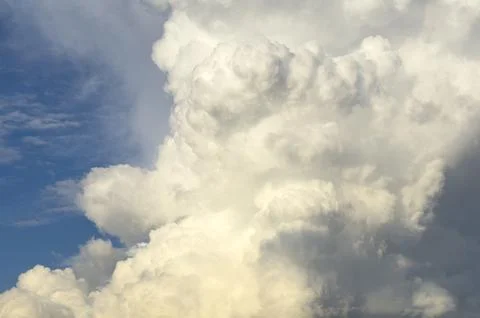 Huge cloud column expands upward in blue sky scene. Billowing cumulus mass Stock Photos