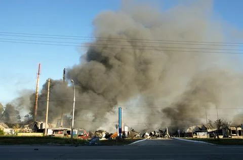 A huge cloud of smoke from an explosion and fire on the outskirts of the city Stock Photos