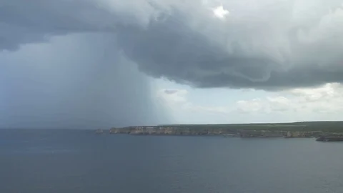 Huge clouds gathered over a piece of land adjoining the sea Stock Footage 77803536