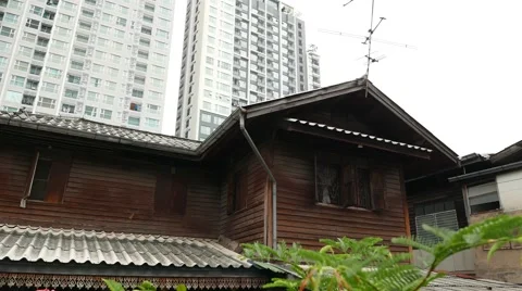 Huge condo tower building after small wooden house, panning shot Stock Footage 53474549