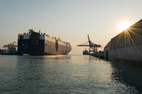 Huge container cargo ship is going to harbor for load car Stock Photos