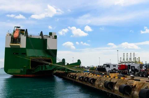 Huge container cargo ship on harbor while load car into it Stock Photos
