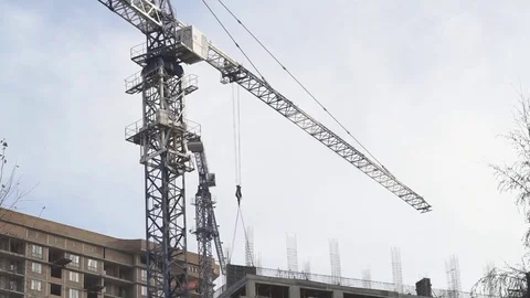 Huge crane rising between building under construction Stock Footage 84665772