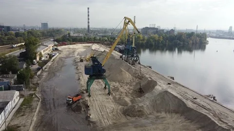 A huge crane scoops up the sand and dumps it into a dump truck. Stock Footage 141868270