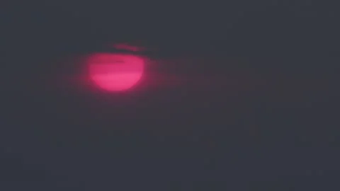 Huge Crimson Sun Emerging Through Dark Clouds Shot on Vintage Telephoto Lens Vídeos de archivo 333367083