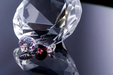 Huge diamond and several chic crystals on a gradient mirror surface, shimmer  Stock Photos