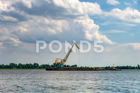 Huge digger in quarry for sand extraction mining in lake Stock Photos