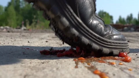 A huge dirty boot crushed a small tomato. Macro. He stepped in and crushed a Stock Footage 140079920