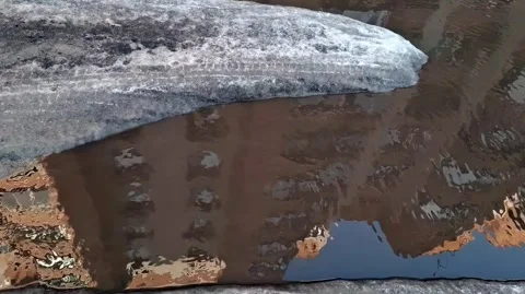Huge dirty puddle forms on road after snow and ice melt in yard in Tvai Stock Footage 337325921