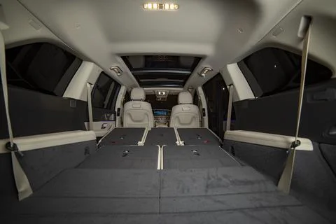 Huge empty car trunk in premium light color interior of suv. rear seats in Stock Photos