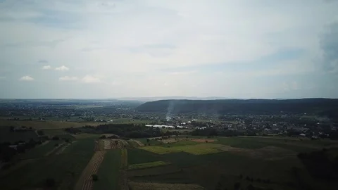 Huge fields, small village, large forests, smoke cloud in the valley. Top view. Stock Footage 114651606