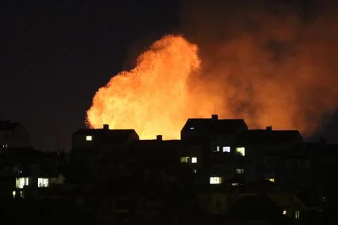 Huge fire and subsequent explosion in a residential neighborhood at night. Stock Photos