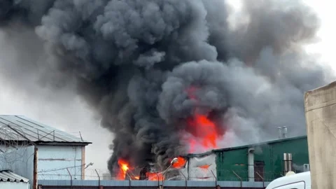 Huge fire burning warehouse with big black smoke cloud Vídeo Stock 323320590
