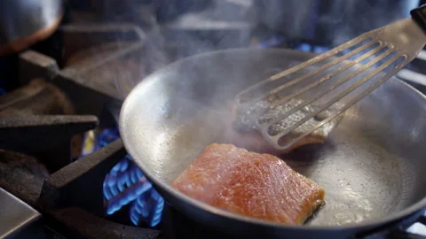 Huge flames shoot out as a chef flips salmon in the restaurant kitchen Stock-Footage 153333217