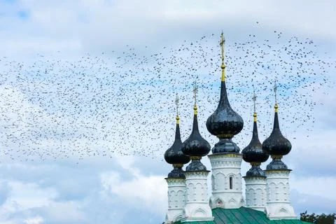 A huge flock of crows over the ancient church of the entrance to Jerusalem, S Stock Photos