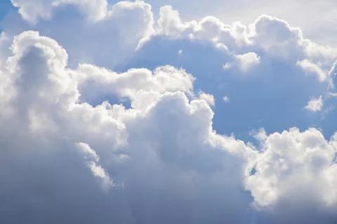 Huge fluffy white cloud and sun rays on a sunny day. Divine heavens Stock Photos