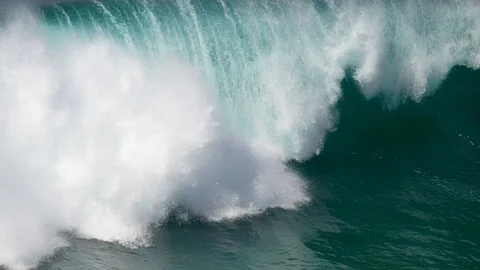 Huge foamy turquoise wave rolling the surface of the ocean. The coast of Stock Footage 107086818