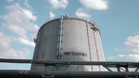 Huge fuel tank with clouds flying in the background. Timelapse Stock Footage 212387993