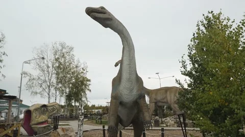 A huge full-length dinosaur in a children's amusement park.Cloudy weather.No one Stock Footage 161246859