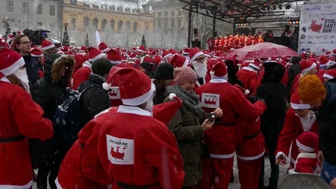 Huge gathering of crowd of Santa Clauses in street heavy snow new year charity Stock Footage 70642092