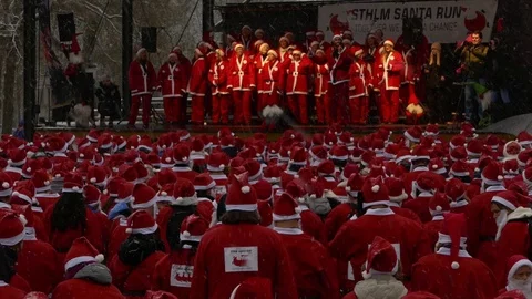 Huge gathering of crowd of Santa Clauses under heavy snow for new year charity Stock Footage 70642319