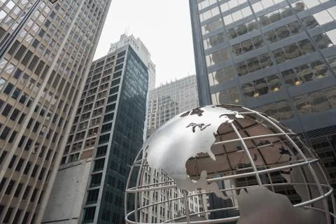 Huge globe situating near multi-storey buildings Stock Photos