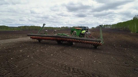 Huge Green Tractor With Sowing System is Preparing for Seeding Crops Stock Footage 127982043