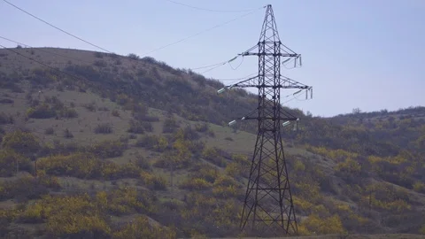 Huge high-voltage electrical supports over the forest Stock Footage 105637944