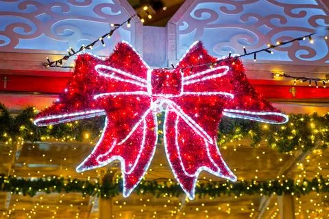Huge illuminated red bow decor at German Christmas market. Stock Photos