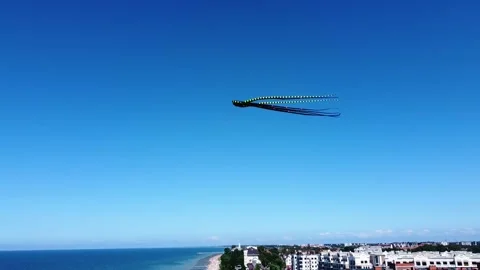 A huge inflatable octopus kite hovers over the city, close-up view from a drone Stock Footage 201065860
