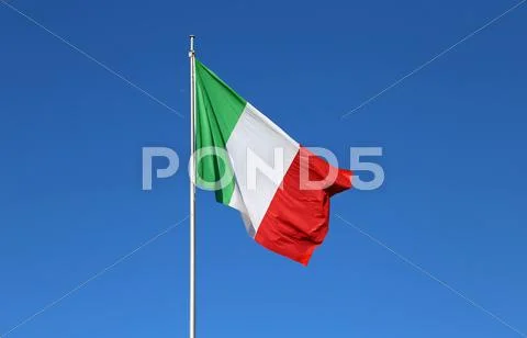Huge Italian flag with the colors red white and green and the blue sky Stock Photos