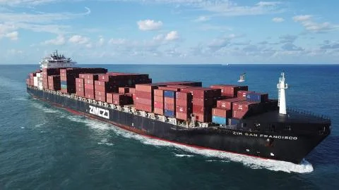 Huge large mega ULCV container ship sails on open water fully loaded Stock Photos