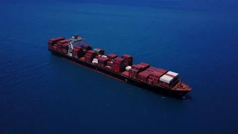 Huge large mega ULCV container ship sails on open water fully loaded Stock Photos
