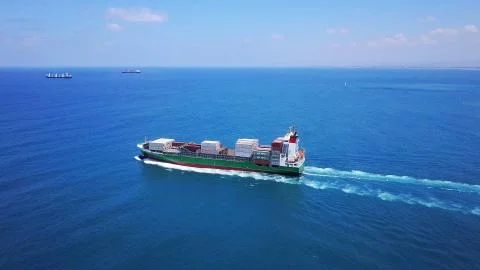 Huge large mega ULCV container ship sails on open water fully loaded Stock Photos