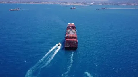 Huge large mega ULCV container ship sails on open water fully loaded Stock Photos