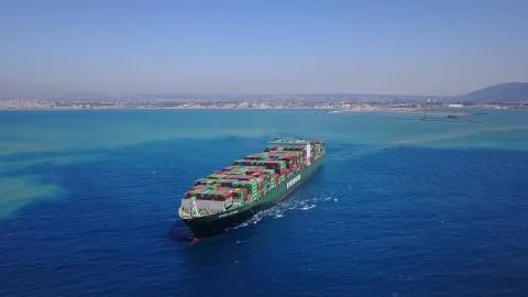 Huge large mega ULCV container ship sails on open water fully loaded Foto stock
