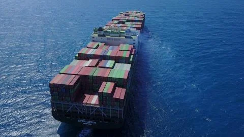 Huge large mega ULCV container ship sails on open water fully loaded Stock Photos
