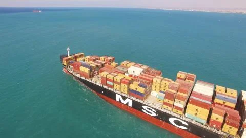 Huge large mega ULCV container ship sails on open water fully loaded Stock Photos