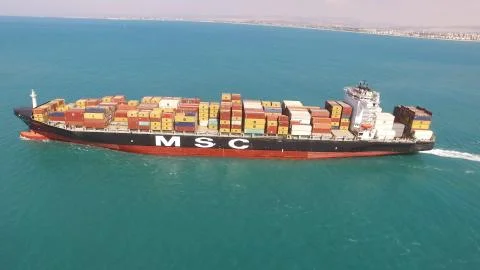 Huge large mega ULCV container ship sails on open water fully loaded Stock Photos
