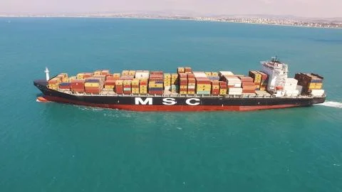 Huge large mega ULCV container ship sails on open water fully loaded Stock Photos