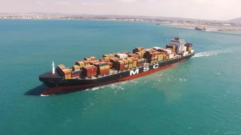 Huge large mega ULCV container ship sails on open water fully loaded Stock Photos