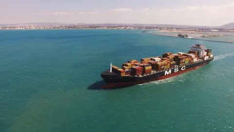 Huge large mega ULCV container ship sails on open water fully loaded Stock Photos