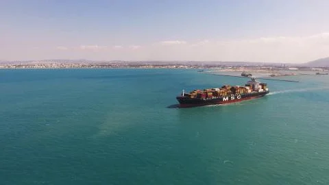 Huge large mega ULCV container ship sails on open water fully loaded Stock Photos