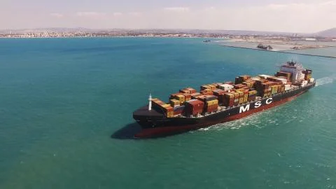 Huge large mega ULCV container ship sails on open water fully loaded Stock Photos