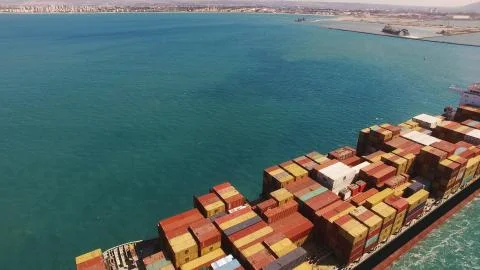 Huge large mega ULCV container ship sails on open water fully loaded Stock Photos