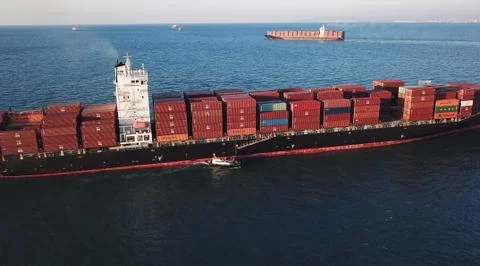 Huge large mega ULCV container ship sails on open water fully loaded Foto stock