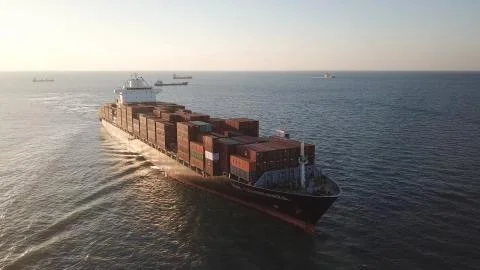 Huge large mega ULCV container ship sails on open water fully loaded Stock Photos