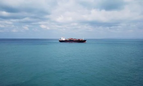 Huge large mega ULCV container ship sails on open water fully loaded Stock Photos